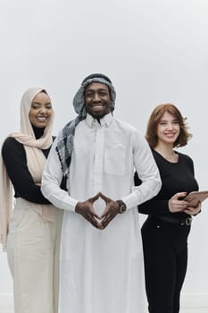 Arabic businessman stands confidently alongside two businesswomen, portraying a poised and diverse team that embodies ambition, innovation, and visionary leadership against a pristine white background.