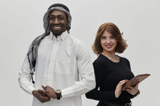 Arabic entrepreneur and a businesswoman, exuding confidence and unity, pose together against a clean white backdrop, symbolizing a dynamic partnership characterized by ambition, innovation, and collaborative success in the business realm.