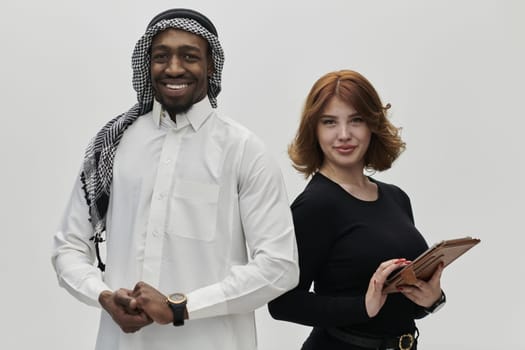 Arabic entrepreneur and a businesswoman, exuding confidence and unity, pose together against a clean white backdrop, symbolizing a dynamic partnership characterized by ambition, innovation, and collaborative success in the business realm.