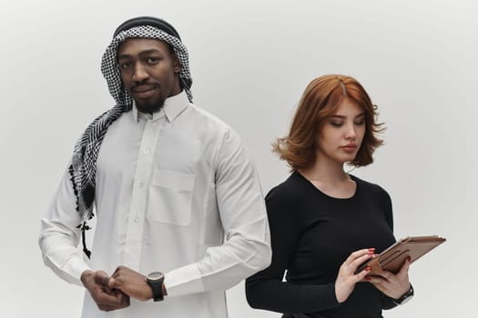 Arabic entrepreneur and a businesswoman, exuding confidence and unity, pose together against a clean white backdrop, symbolizing a dynamic partnership characterized by ambition, innovation, and collaborative success in the business realm.