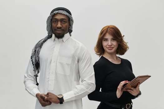 Arabic entrepreneur and a businesswoman, exuding confidence and unity, pose together against a clean white backdrop, symbolizing a dynamic partnership characterized by ambition, innovation, and collaborative success in the business realm.