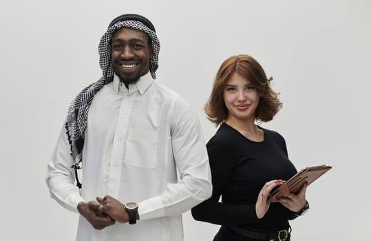 Arabic entrepreneur and a businesswoman, exuding confidence and unity, pose together against a clean white backdrop, symbolizing a dynamic partnership characterized by ambition, innovation, and collaborative success in the business realm.