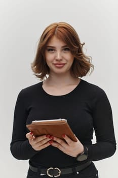 In a powerful display of modern professionalism, a confident red-haired businesswoman strikes a pose with a tablet against a clean white background, embodying ambition, innovation, and corporate charisma in the contemporary business landscape.