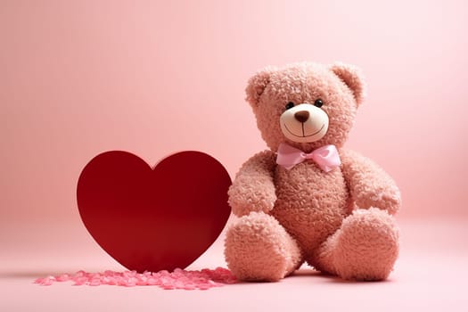 A pink teddy bear next to a red heart on a pink background