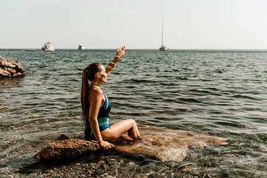 Woman beach vacation photo. A happy tourist in a blue bikini enjoying the scenic view of the sea and volcanic mountains while taking pictures to capture the memories of her travel adventure