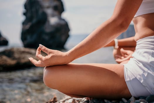 Woman sea yoga. Back view of free calm happy satisfied woman with long hair standing on top rock with yoga position against of sky by the sea. Healthy lifestyle outdoors in nature, fitness concept.