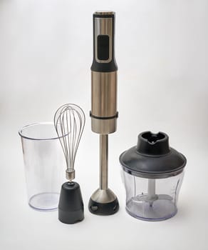Immersion hand blender with various attachments and two cups. Electric kitchen appliances for making sauces, smoothies, purees. Hand mixer set.