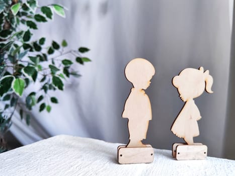 Wooden toys boy and girl on a fabric background. Couple in love on Valentine's Day. A celebration of love, friendship and tenderness
