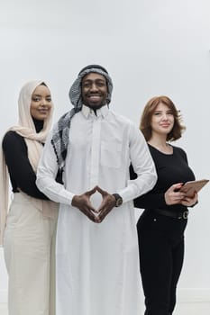 Arabic businessman stands confidently alongside two businesswomen, portraying a poised and diverse team that embodies ambition, innovation, and visionary leadership against a pristine white background.