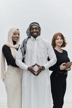 Arabic businessman stands confidently alongside two businesswomen, portraying a poised and diverse team that embodies ambition, innovation, and visionary leadership against a pristine white background.