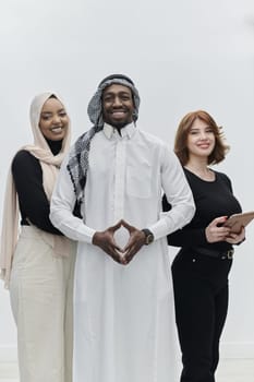 Arabic businessman stands confidently alongside two businesswomen, portraying a poised and diverse team that embodies ambition, innovation, and visionary leadership against a pristine white background.