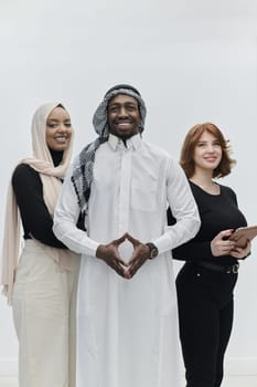 Arabic businessman stands confidently alongside two businesswomen, portraying a poised and diverse team that embodies ambition, innovation, and visionary leadership against a pristine white background.
