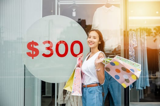 A stylish woman with shopping bags in front of a trendy store window. The perfect shopping day in the city with fashion and consumerism.