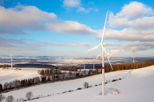 Panoramic view of wind farm or wind park, with high wind turbines for generation electricity with copy space.