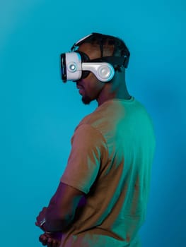 In a futuristic visual, an African American man stands isolated against a striking blue backdrop, adorned with VR glasses that transport him into a cutting-edge virtual reality experience, merging technology and innovation in a contemporary display.