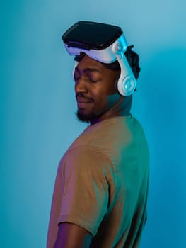 In a futuristic visual, an African American man stands isolated against a striking blue backdrop, adorned with VR glasses that transport him into a cutting-edge virtual reality experience, merging technology and innovation in a contemporary display.