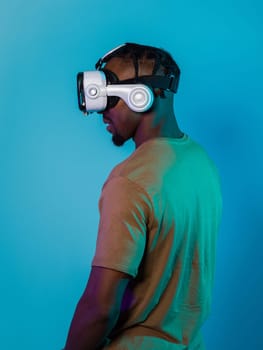 In a futuristic visual, an African American man stands isolated against a striking blue backdrop, adorned with VR glasses that transport him into a cutting-edge virtual reality experience, merging technology and innovation in a contemporary display.