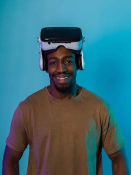 In a futuristic visual, an African American man stands isolated against a striking blue backdrop, adorned with VR glasses that transport him into a cutting-edge virtual reality experience, merging technology and innovation in a contemporary display.