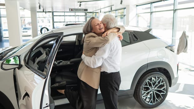 Mature Caucasian couple hugging. Elderly man and woman buying a new car