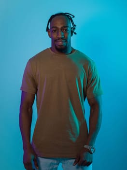 African American man with a modern and sophisticated hairstyle stands confidently against a vibrant blue backdrop, showcasing a blend of contemporary fashion and cultural identity with elegance and charisma.