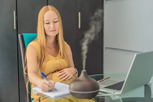 Expectant woman enhances work environment, using an aroma diffuser for a soothing atmosphere during pregnancy.