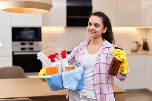 Woman in rubber protective yellow gloves holding cleaning tools. house chores.