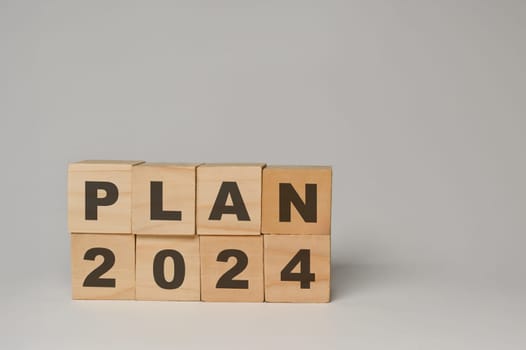 Wooden cube blocks with 2024 PLAN word on white background. Business action plan, goals and strategy concept.