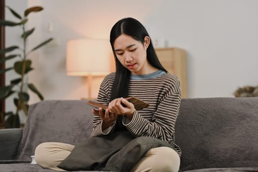 Portrait of young woman reading book literature at cozy home, spending weekend leisure time.