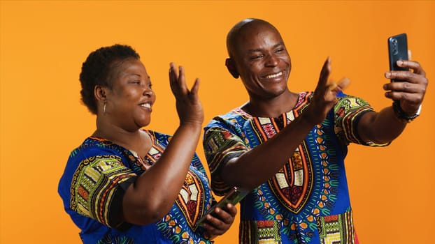 Ethnic couple discussing on videocall connection, meeting with family on internet network. African american man and woman using smartphone app to talk to people on teleconference call.