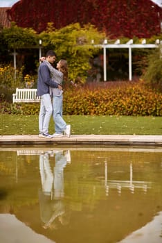 lovely young couple kissing outdoors in autumn. Loving couple walking in nature. Autumn mood. Happy man and woman hugging and kissing in autumn. Love. Fashionable couple outdoors. Fashion, people and lifestyle. Stylish couple in autumn outfit.