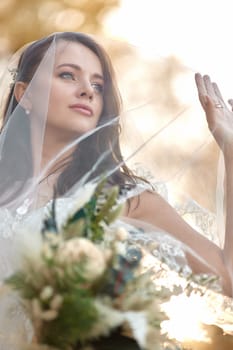 beautiful happy bride in veil holding wedding autumn bouquet