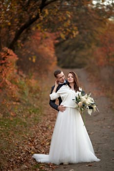 happy bride in white wedding dress and groom standing outdoor on natural background