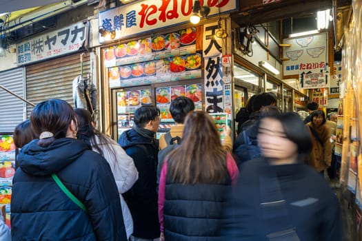 Tokyio, Japan. January 2024. People queuing to buy food at stalls at the Tsukiji Outer Market in the city centre