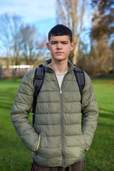 Youthful Elegance: Beautiful 17-Year-Old Boy Standing in the Autumn Park with Lush Green Lawn. Captivate your audience with the graceful charm of this image featuring a beautiful 17-year-old boy standing in the vibrant autumn park. The lush green lawn serves as a picturesque backdrop, creating a perfect blend of youthful elegance and the enchanting colors of fall.