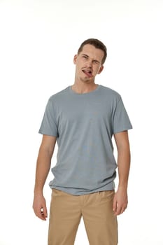 young man shows her toung, feels disgust on white background.