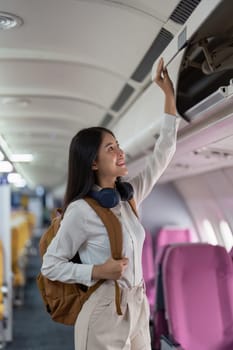 Alone Asian woman passenger traveling by plane. happy traveler on board. Solo travel concept.