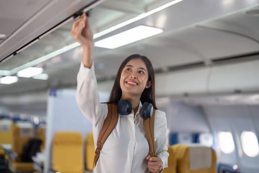 Alone Asian woman passenger traveling by plane. happy traveler on board. Solo travel concept.