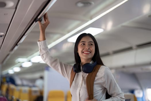 Alone Asian woman passenger traveling by plane. happy traveler on board. Solo travel concept.