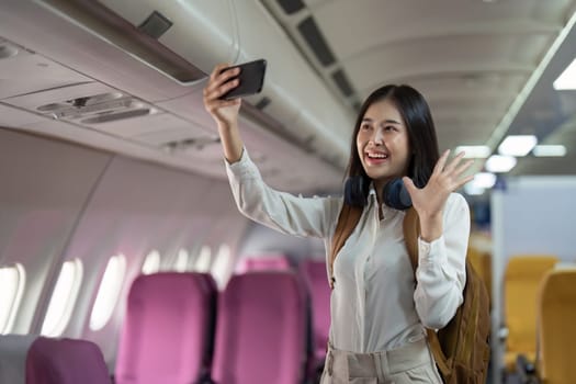 Alone Asian woman passenger traveling by plane. happy traveler on board. Solo travel concept.