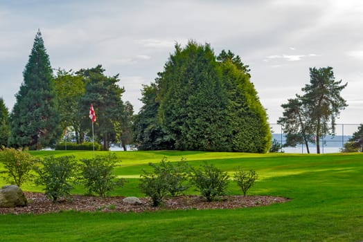 Scenic view of a golf field with checkered flags against the backdrop of the Pacific Ocean bay