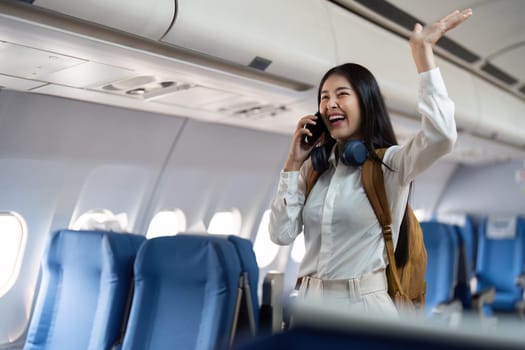 Alone Asian woman passenger traveling by plane. happy traveler on board. Solo travel concept.