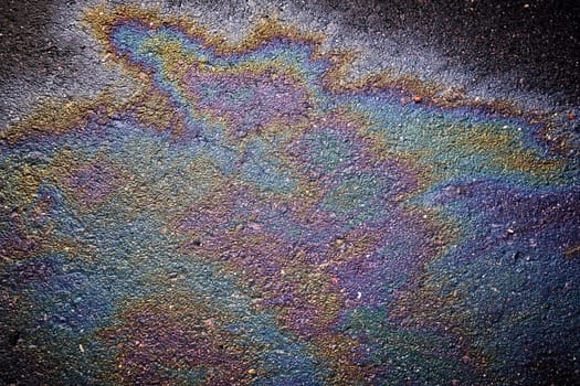 Oil, gasoline, or oil spill on wet asphalt with a parking lot and a dividing line