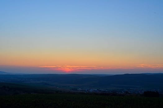 Landscape at twilight with red sky. Romantic sunset with red clouds. Countryside during the blush of dawn.