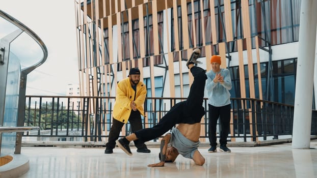 Hip hop team dance break dance while multicultural friend surrounded and clapping hands to cheer or encourage his friend to dance. Active and energetic street dance. Outdoor sport 2024. Endeavor.