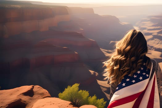 Woman with an American flag on the edge of a canyon at sunset. US Independence Day
