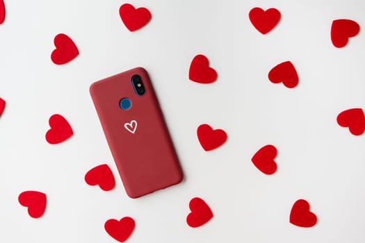 A red smartphone with a heart icon, surrounded by small red hearts on a white background