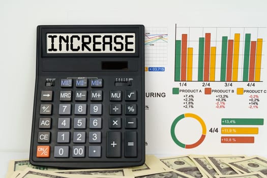 Business concept. On the table are financial reports, dollars and a calculator with the inscription - INCREASE
