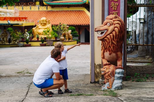 Father and son tourists walking in Vietnam Buddhist Temple, happy childhood, exploring world.