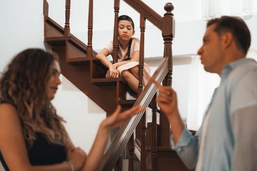 Stressed and unhappy young girl watch her parent arguing from the stair. Domestic violence at home and traumatic childhood develop to depression and anxiety. Unhealthy family concept. Synchronos