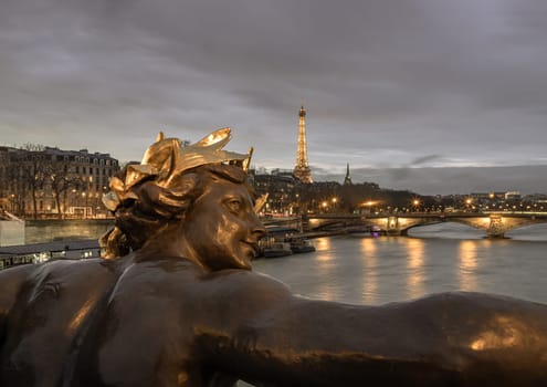 France, Paris - Jan 4, 2024 - Nice scenery of Golden statue adorning Pont Alexandre III Bridge over the Seine River and Eiffel Tower in Paris at sunset. Destinations in Europe. Space for text, Selective focus.